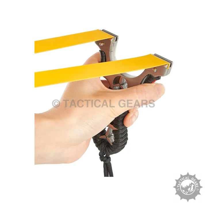 Hand holding a Professional Mercedes Slingshot with yellow flat bands and black paracord handle