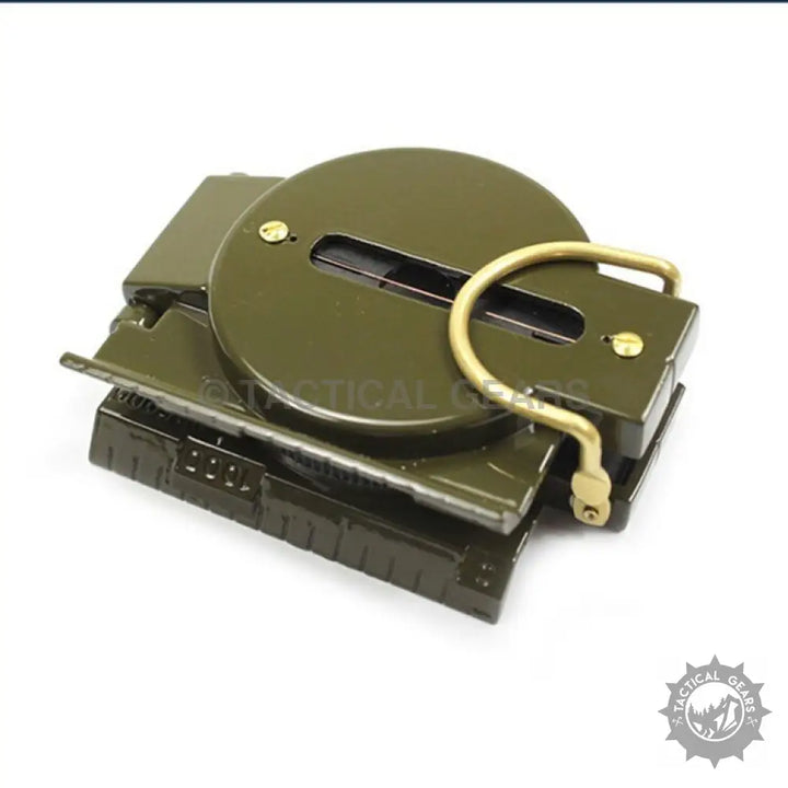 Olive green military-style lensatic compass with brass thumb loop showing compass card and magnetic heading