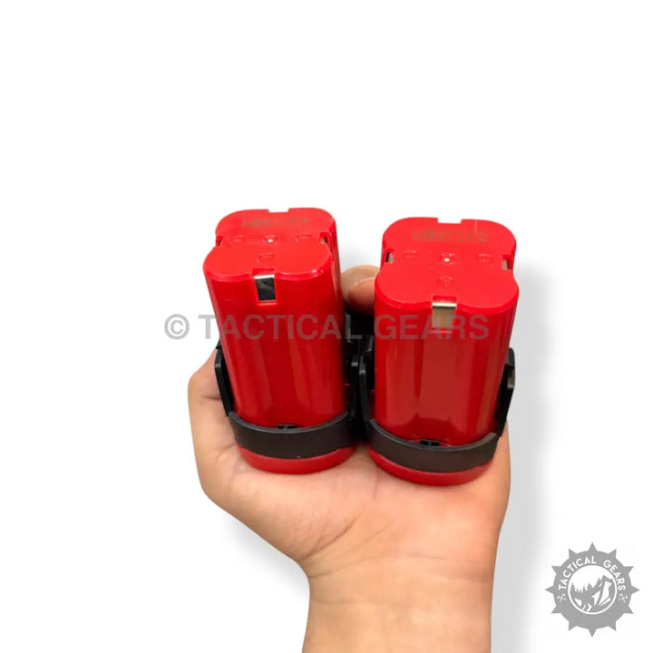 Milwaukee 28v rechargeable drill batteries with black holsters held in hand