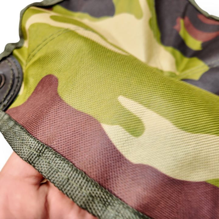 Camouflage fabric with visible weave and stitched edge on mini portable folding camping stool