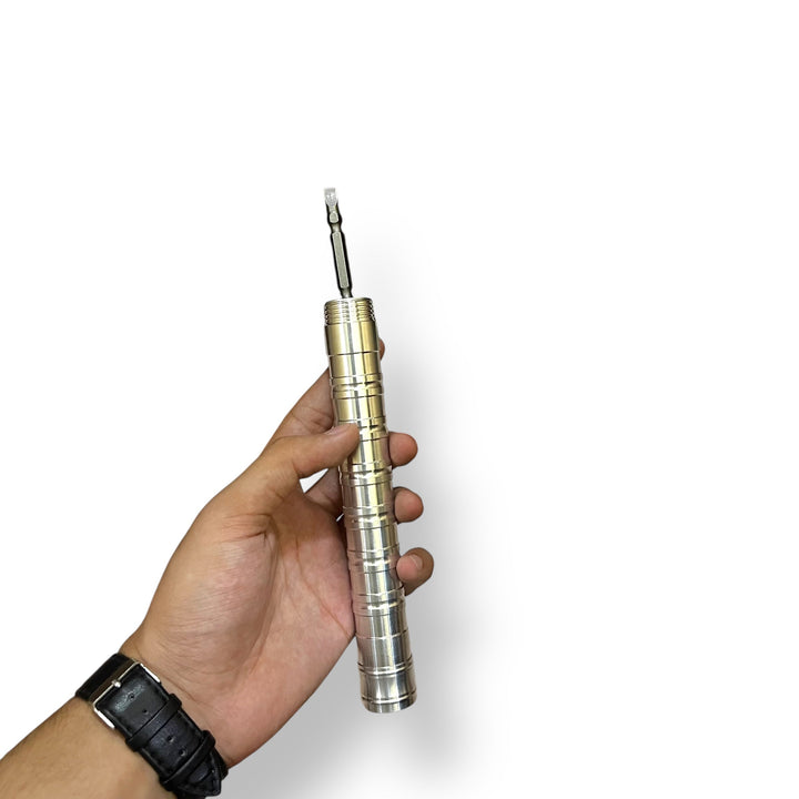 Hand holding metallic multi-bit screwdriver on Multi Tactical Shovel with imported multi foldable design