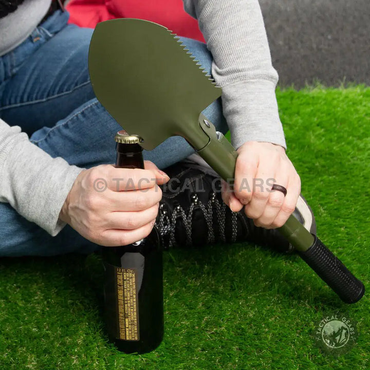 Portable camping shovel in green with bottle opener, ideal for outdoor camping trips