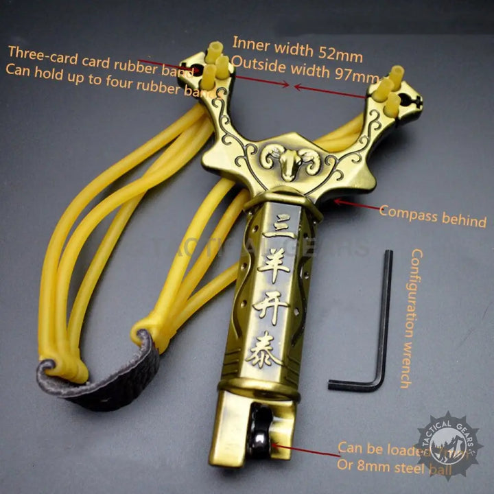 Brass-colored hunting slingshot with yellow rubber bands and steel ball dispenser