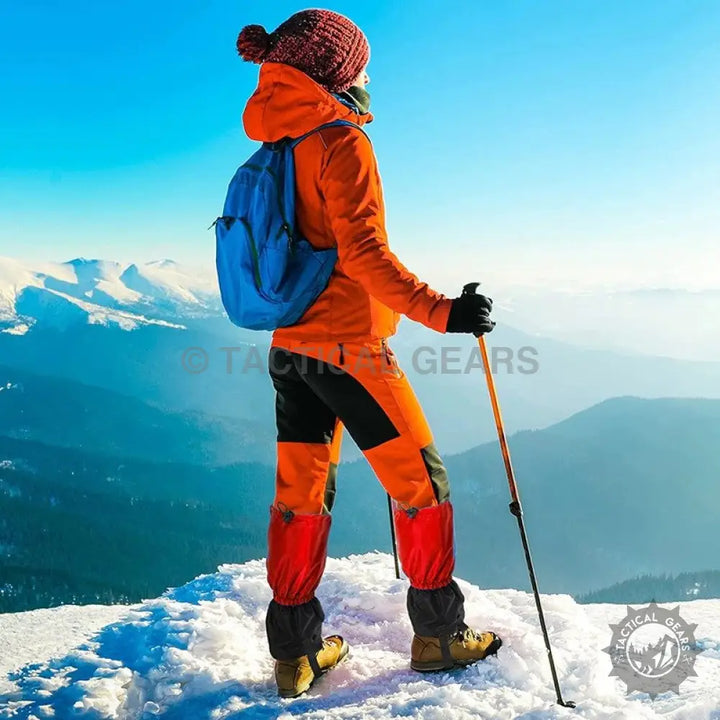 Hiking gaiters worn by a person in orange and black winter hiking gear with a blue backpack