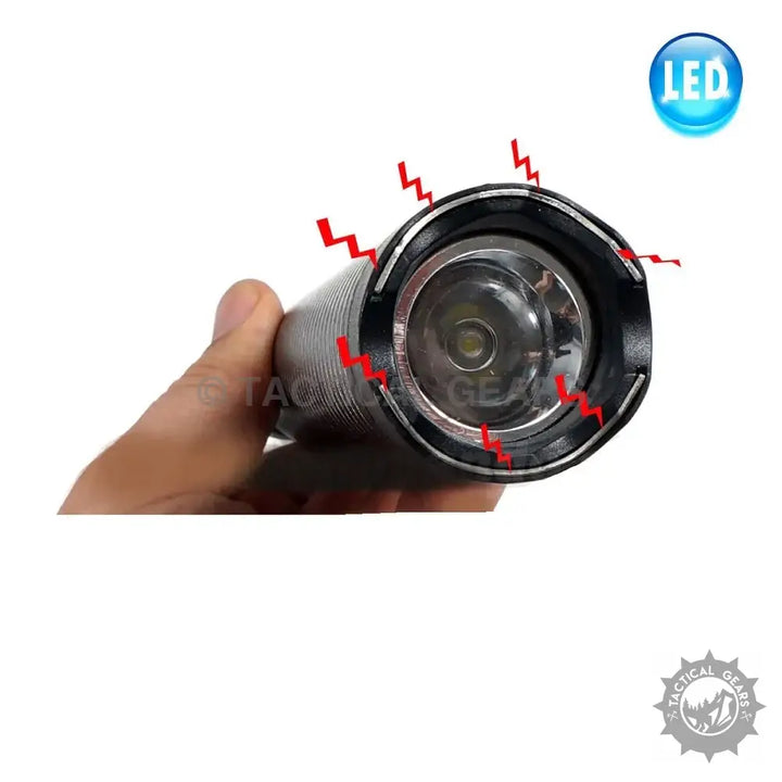 Hand holding a Paralyzer High Voltage Pulse Baton with LED bulb and red electrical discharge