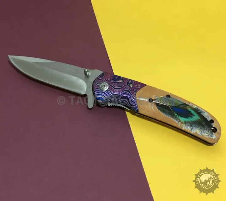 Folding Jeep DA153 Tactical Survival Knife with silver blade, patterned bolster, and peacock feather handle