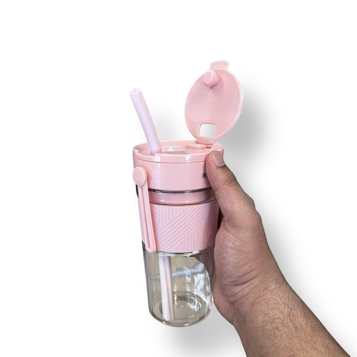 Pink and clear reusable tumbler with straw and flip-top lid for portable blender use