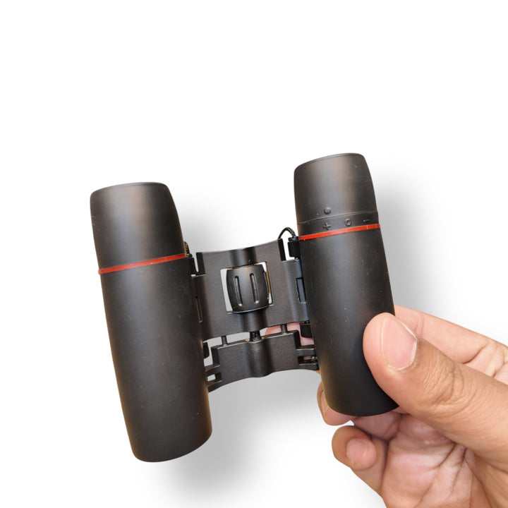 Black compact pocket size mini binoculars with red rings on each eyepiece for easy viewing