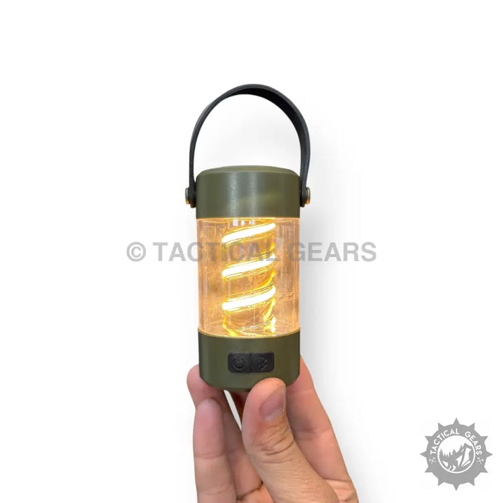 Olive green portable camping light with built-in Bluetooth speaker and glowing spiral filament