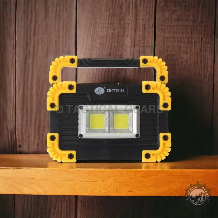 Black and yellow portable LED work light with handle for illuminating work areas