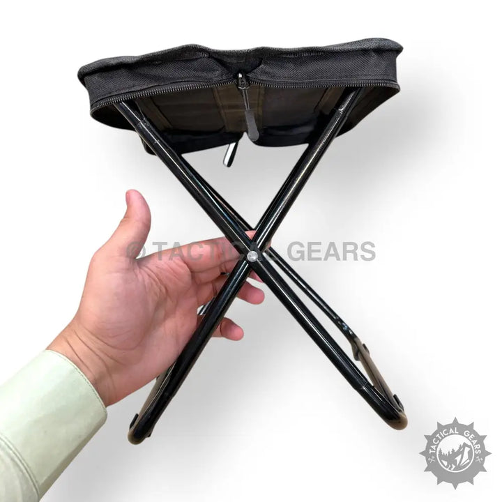 Black portable folding camping stool with zippered storage compartment for outdoor use