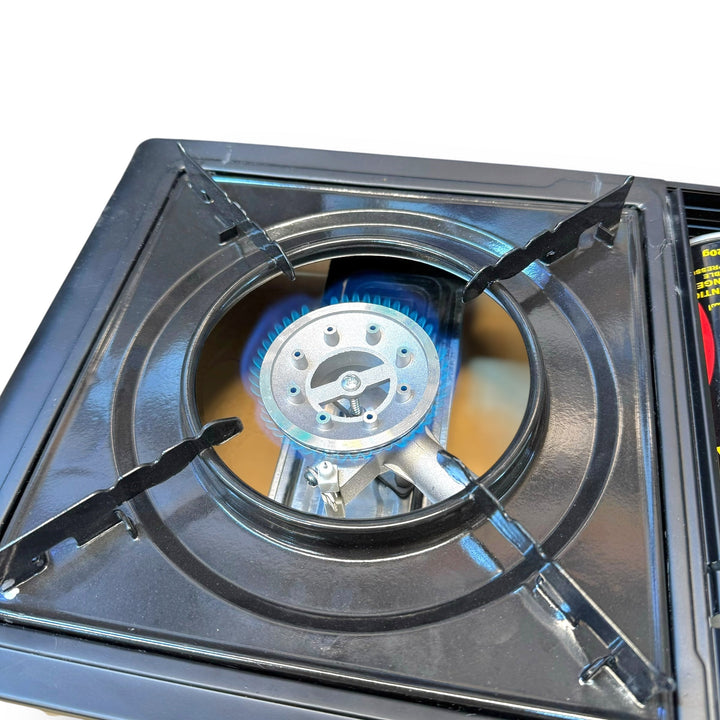 Portable gas burner stove with lit burner and case for outdoor cooking and camping