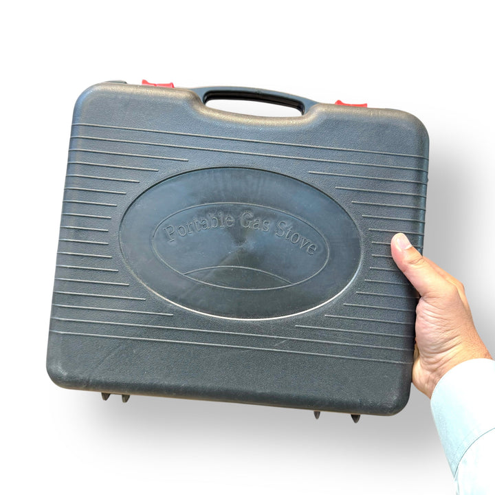 Dark gray portable gas burner stove in protective carrying case for travel and outdoor use