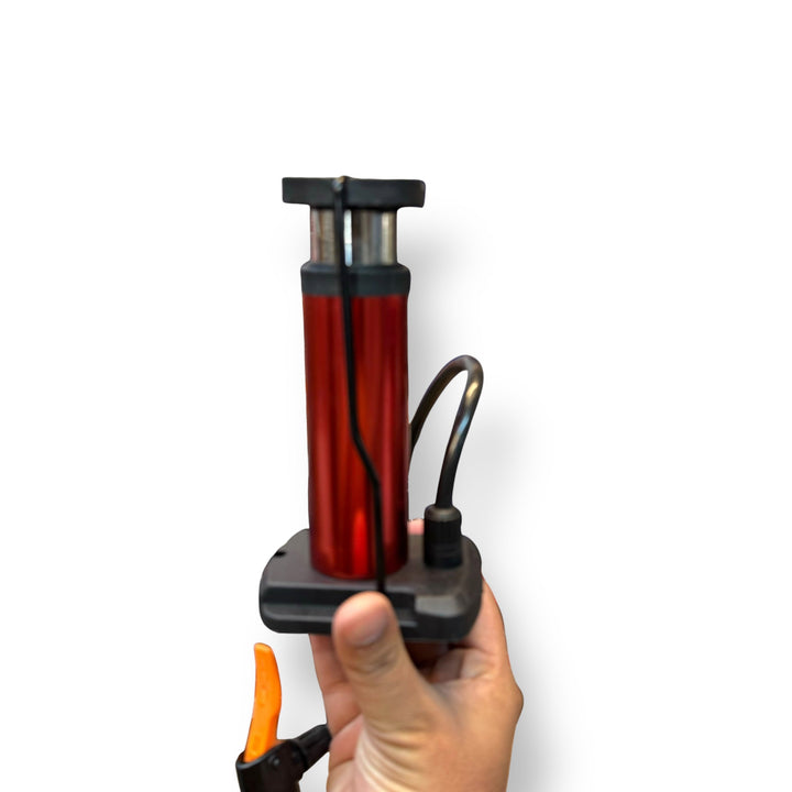 Red and black imported mini foot pump with hose and orange lever for easy inflation