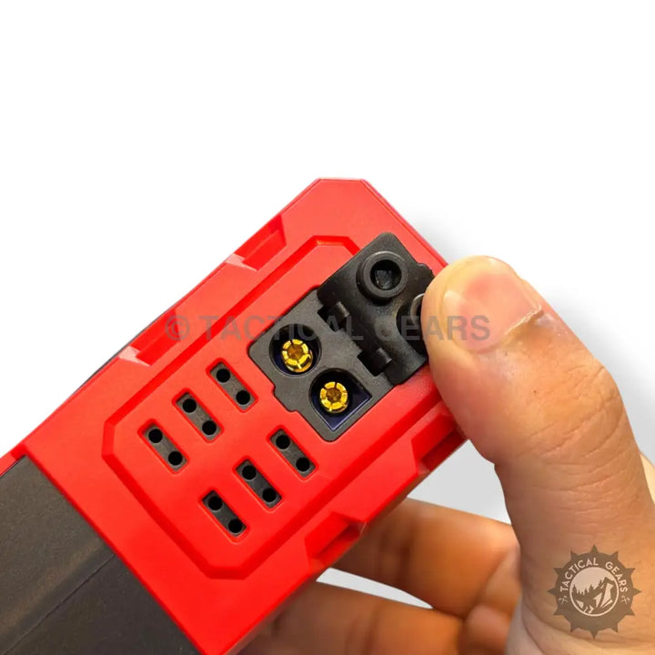 Red and black portable jump starter and tire inflator with gold connectors and slots