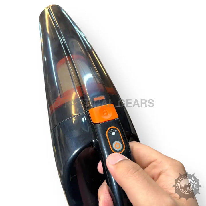 Black portable rechargeable vacuum cleaner with orange power button for car cleaning