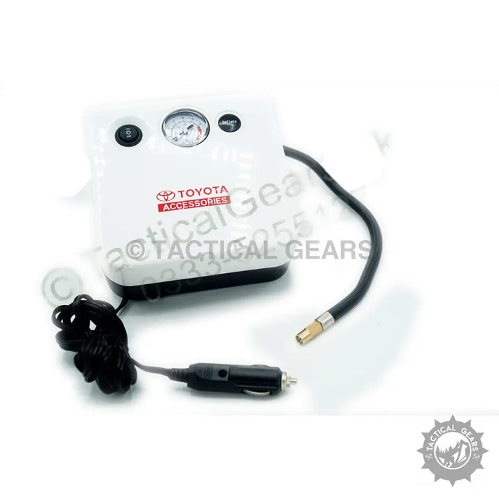 White portable Toyota air compressor with analog gauge, flexible hose, and 12V adapter