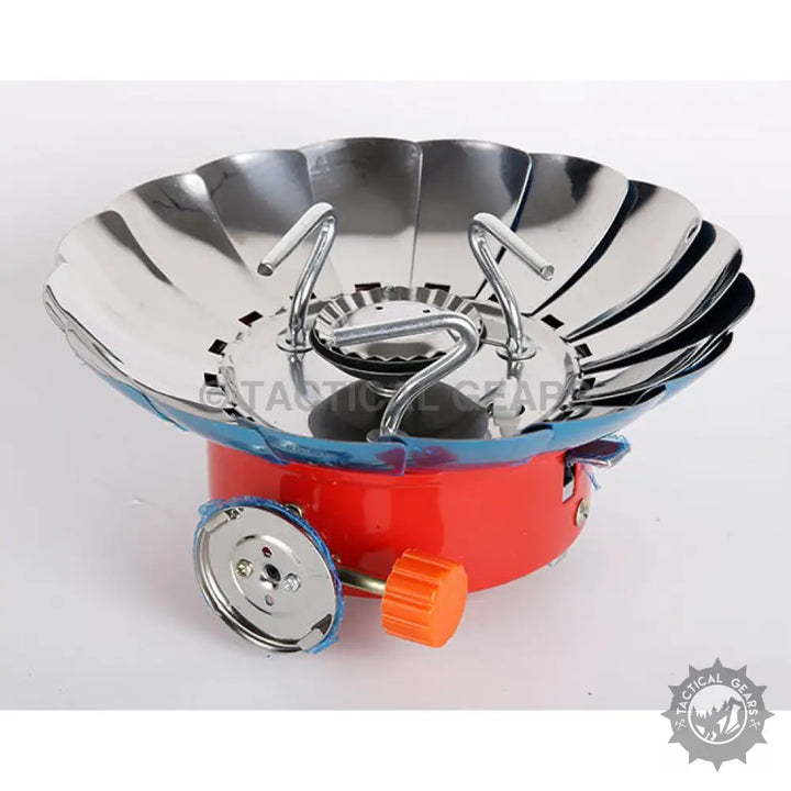 Portable red and silver windproof camping stove with integrated wind guard for outdoor cooking
