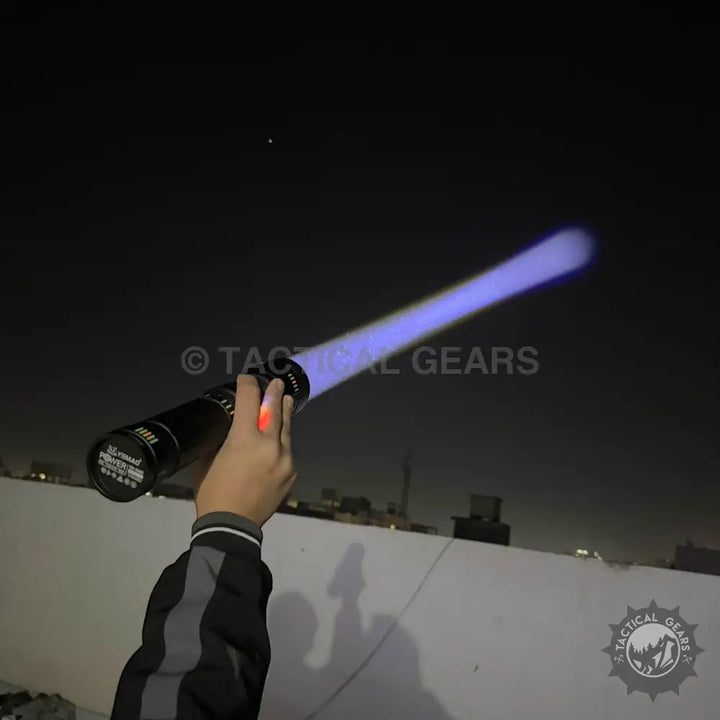 Hand holding a Powerful Tactical 3km LED Flashlight with a purple beam for outdoor use