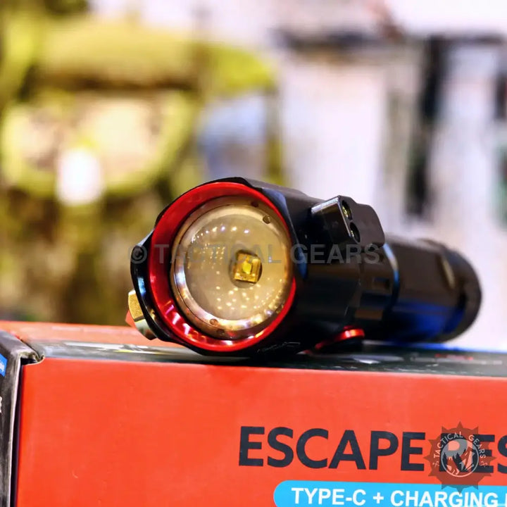 Powerful tactical torch with red bezel, visible LED emitter, 1-km range, hours battery