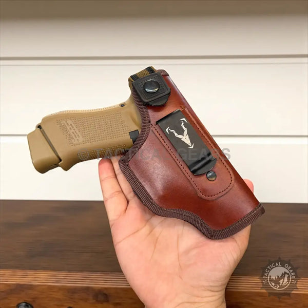 Leather IWB Holster with tan pistol in brown leather holster and black metal clip