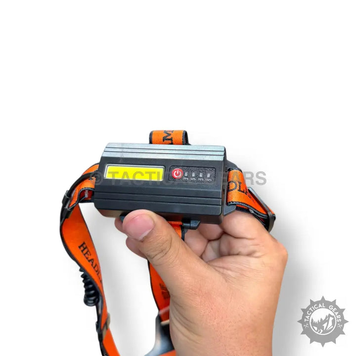 Rechargeable Headlight with black headlamp, orange straps, and battery indicator for outdoor use