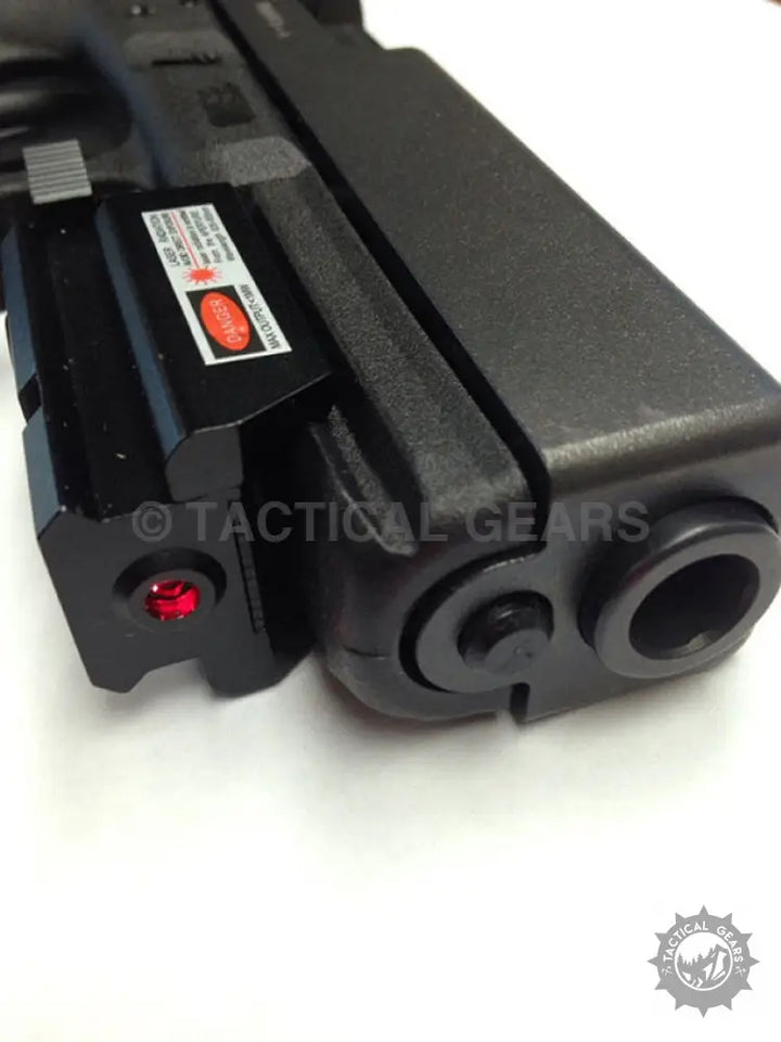Black handgun with attached red dot laser sight beam for precise aiming