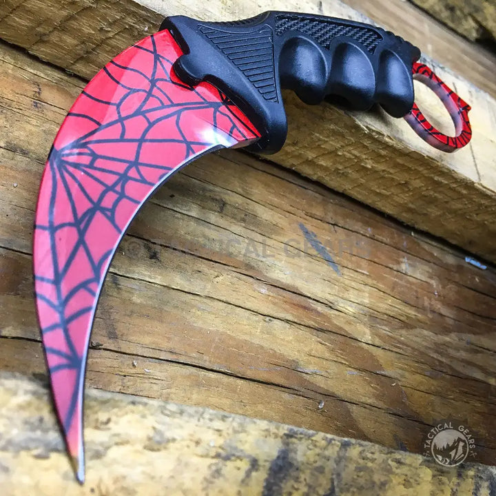 Red karambit knife with black spiderweb pattern and textured handle for Spiderman Crack Pattern Karambit Knife