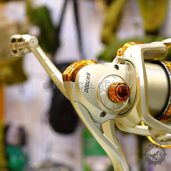 Gold and silver fishing reel with orange accents on Retractable Fishing Rod Set product