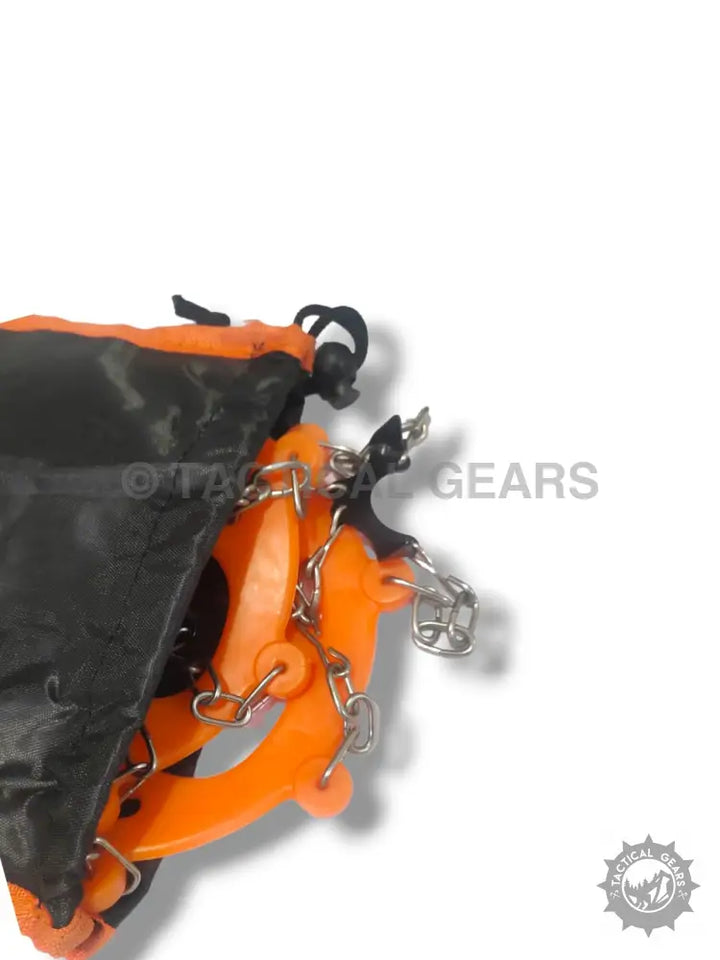 Orange and black snow grips crampons with metal chains in a black pouch for ice traction