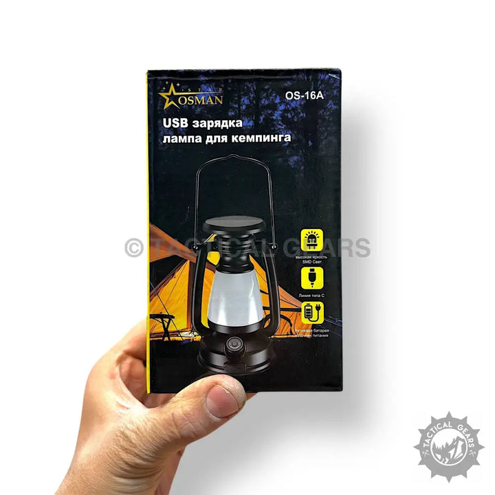 Hand holding a black Solar Camping USB Rechargeable Lamp, a portable usb rechargeable lamp
