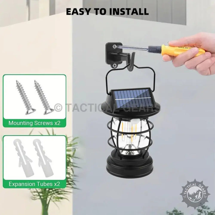 Black solar-powered camping lantern with cage design, visible filament bulb, and light sensor
