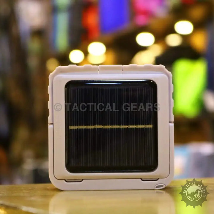 Solar powered camping lantern with compact white design and black solar panel