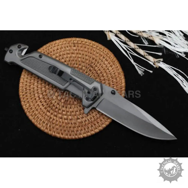 Gray tactical folding knife with textured handle and belt clip, ideal for camping and hunting