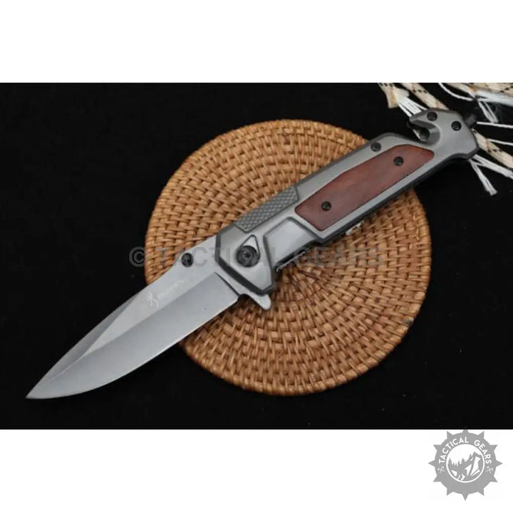 Stainless steel folding knife with dark wood handle and glass breaker tip for camping