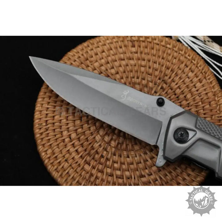 Gray folding knife with tanto-style blade and ergonomic handle, ideal for camping and hunting