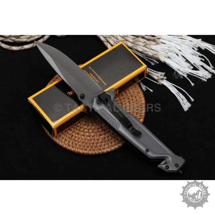 Gray tactical folding knife with sharp blade and belt clip for camping and hunting use