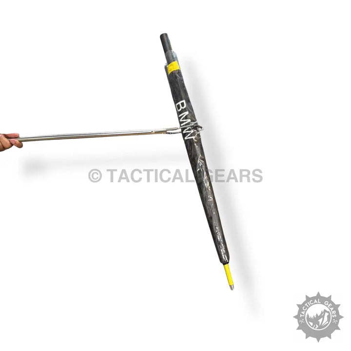 Black umbrella with yellow tip held by hand, stainless steel steel snack catcher tool