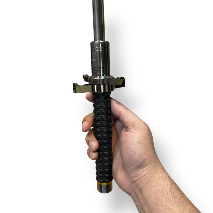 Hand holding a black textured grip military baton with silver shaft for Tactical Military Batons