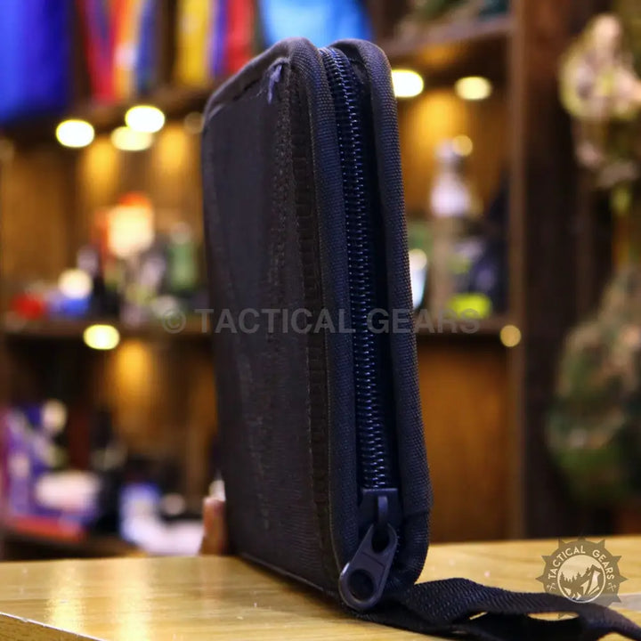 Black tactical safety case with zippered pouch and fabric loop for secure storage