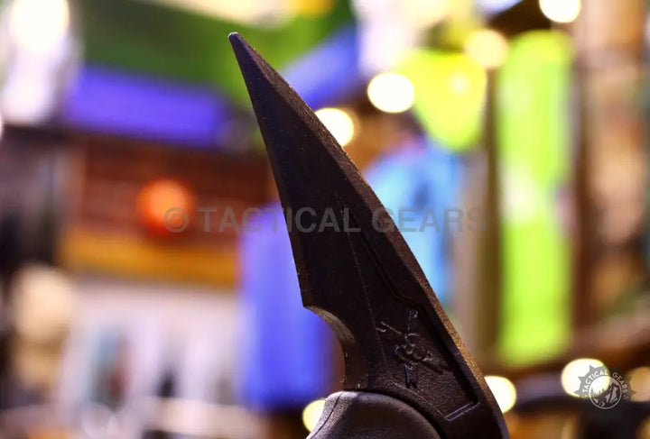 Black tactical knife with skull handle on Tactical Tomahawk M-48 Axe cutting surface