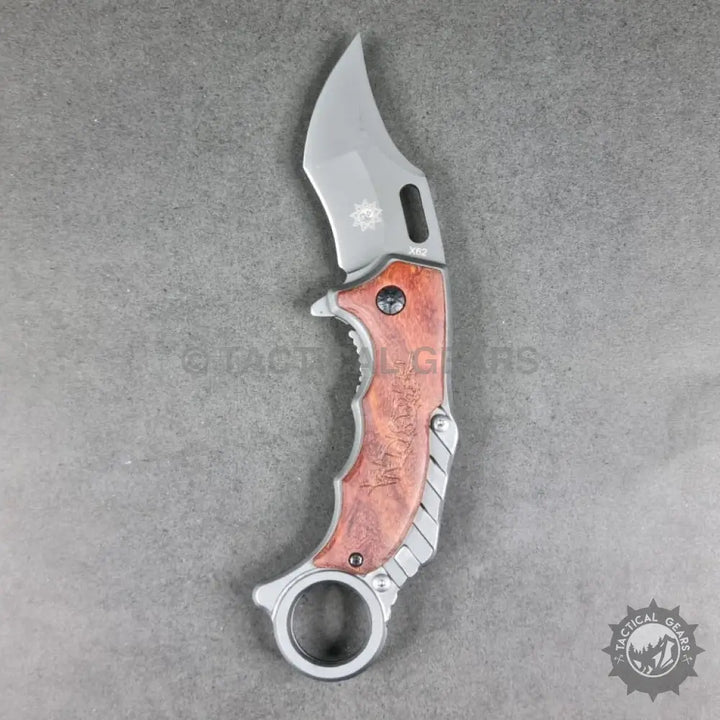 Tactical X62 Karambit folding knife with curved blade, wooden handle, and finger ring