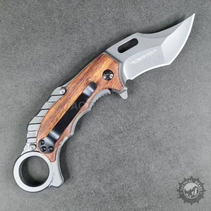 Tactical X62 Karambit folding knife with wooden handle, pocket clip, and finger ring