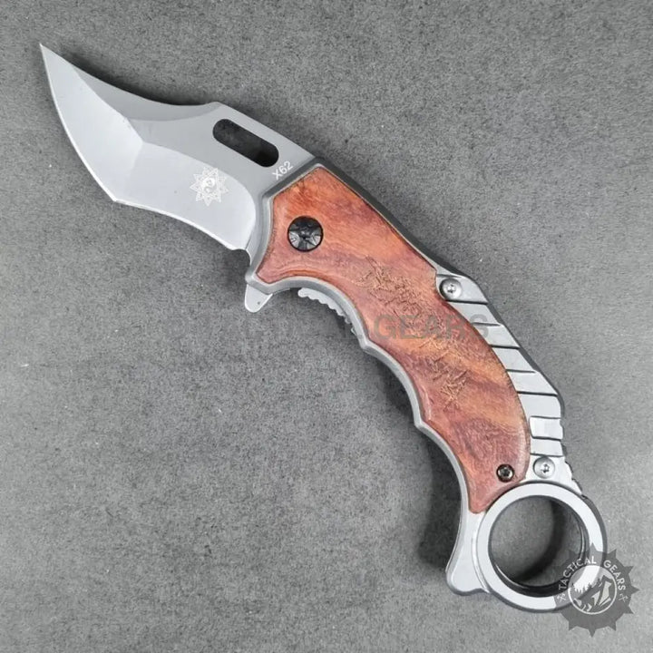Tactical X62 Karambit folding knife with curved blade, wooden handle, and finger ring