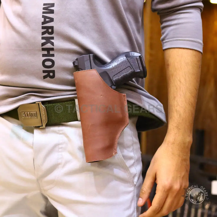 Person wearing grey shirt white pants and green belt with universal belt holster