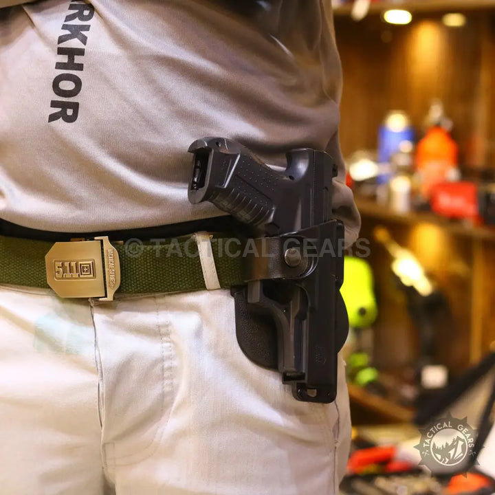Universal polymer holster with magazine pouch holding a black pistol on a green tactical belt
