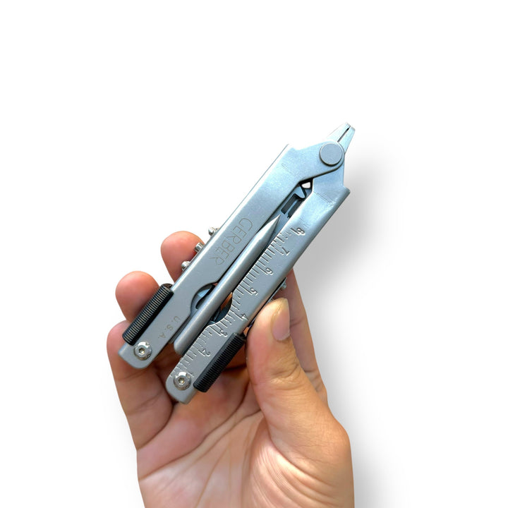 Silver multifunctional plier tool with folded implements including ruler and pointed tip, USA lot imported