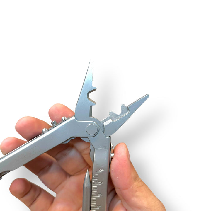 Silver multifunctional plier tool held by person USA lot imported versatile multi-tool