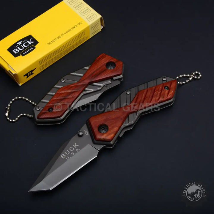 Dark gray Buck USA X59 Tactical Mini Folding Knife with reddish-brown wood handle