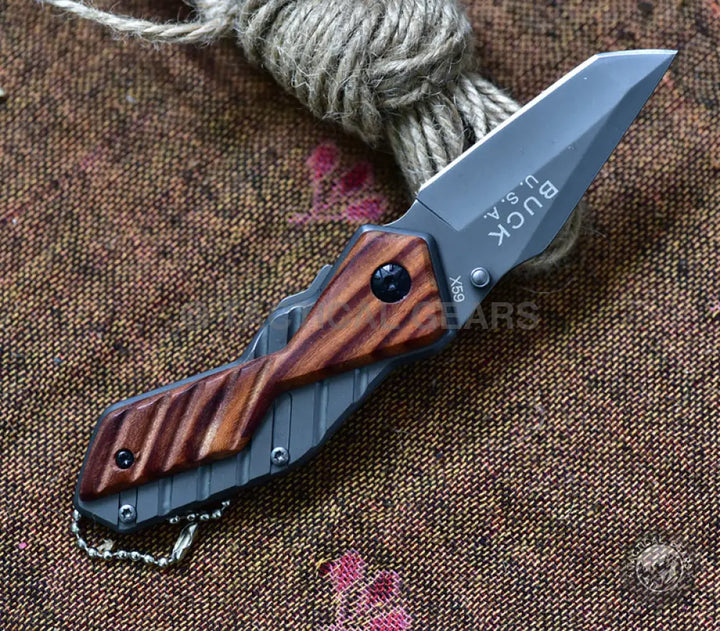 Buck USA X59 Tactical Mini Folding Knife with gray metal frame, dark blade, and wooden handles